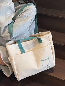 Minimalist canvas tote bag with blue straps and cute cat embroidery for casual daily wear