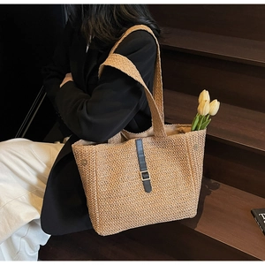 Détail du sac cabas en paille tissée avec boucle en cuir noir et grande capacité de rangement