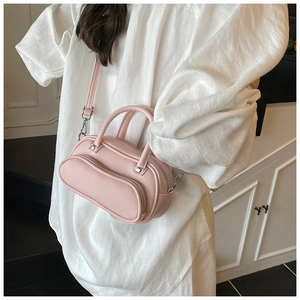 Detail shot of a pink litchi grain mini bowling bag with round front pocket and strap