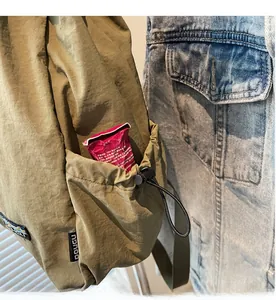 Vue détaillée d'un sac à dos en nylon vert armée avec poche latérale à cordon réglable