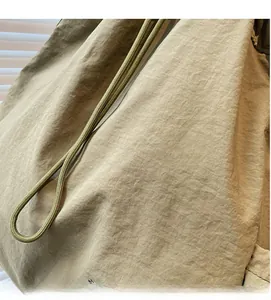 Détail du tissu en nylon plissé doux et du cordon de serrage tissé du sac à dos