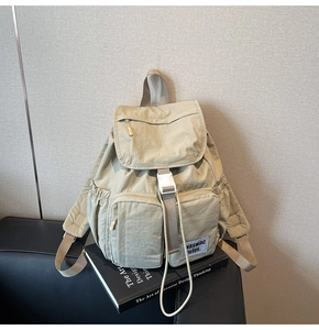 Close-up of the waterproof fabric and buckle closure on the beige travel backpack