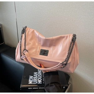 Close-up of pink glossy tote bag with metal chain strap and turn-lock closure detail