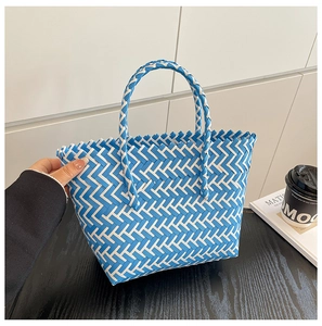 Detailed close-up of blue and white V-shape woven texture on summer straw tote bag