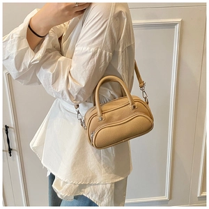 Litchi texture beige Boston bag shown worn by model with adjustable shoulder strap