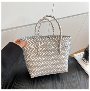 Détail du panier tissé à la main en plastique contrasté gris et blanc avec double poignées