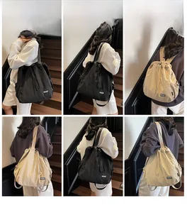 Vues détaillées du mannequin portant le sac à dos polyvalent à cordon en noir et beige