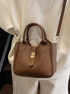 Elegant brown lychee pattern leather bucket bag with gold hardware and shoulder strap