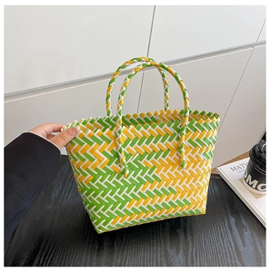 Détail du sac panier tressé avec motifs diagonaux vert, jaune et blanc
