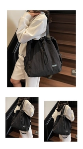 Vue détaillée du sac à dos en nylon noir imperméable avec étiquette bleue distinctive