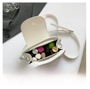 Detail view of white lychee leather mini crossbody bag showing internal storage capacity