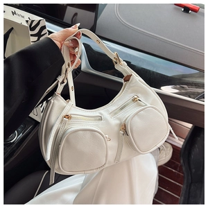 Macro shot of white leather hobo bag detailing zip pockets and adjustable strap