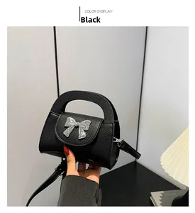 Detail of black bow-knot handbag with textured leather and adjustable strap