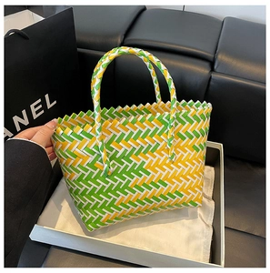 Detail of handwoven tote bag in green, yellow, and white geometric summer pattern