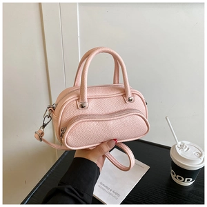 Detailed macro view of the lychee grain texture on a pink mini boston bag with handle