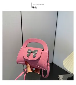 Close-up of pink bow mini crossbody bag with pebble texture and silver hardware