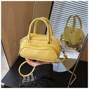 Detailed macro view of yellow lychee texture leather handbag with silver metal hardware