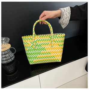Detailed weave of the green, yellow, and white straw basket bag for summer vacations