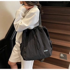 Détail du sac fourre-tout en nylon noir avec cordon de serrage et étiquette tissée