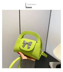 Detail showing the neon green pebble leather texture and metallic silver bow on the bag