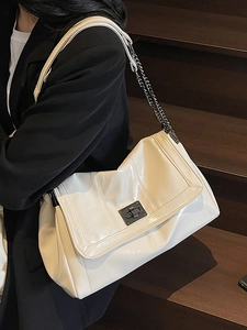 Retro cream faux leather tote bag with metallic chain strap and turn-lock closure on model