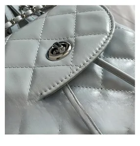 Close-up of light blue quilted leather bag showing silver twist lock and chain strap