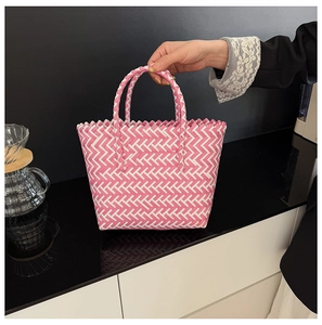 Detailed close-up showing pink and white woven herringbone pattern on a beach basket bag