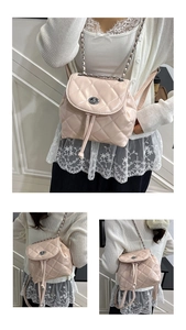 Detail of light pink quilted mini backpack with silver chain straps and turn-lock closure