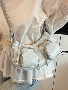Metallic blue half-moon crossbody bag with zippers in stylish punk biker fashion