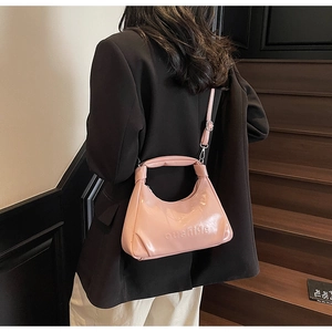 Pink waxed leather half-moon handbag with a knotted handle shown on model in modern setting