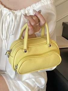 Yellow litchi pattern mini Boston pillow bag with dual handles and stylish zipper detail