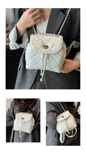 Detail view of a white quilted mini backpack with chain straps and metal twist lock