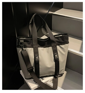 Detail of the large two-tone tote bag with black clips and adjustable shoulder strap