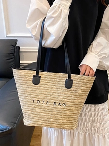 Minimalist straw tote bag with black leather straps and Tote Bag embroidery detail