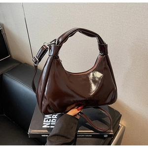 Close-up of dark brown wax leather hobo bag with knotted handle and silver hardware