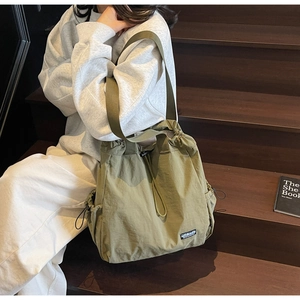 Détail du sac en nylon vert olive avec fermeture à cordon et logo de la marque