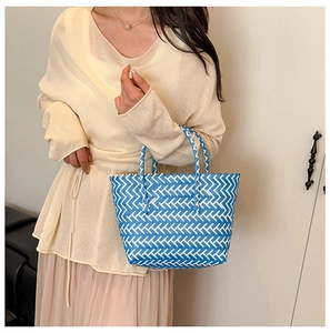 Detail of blue and white woven basket bag with V-shaped herringbone pattern for summer