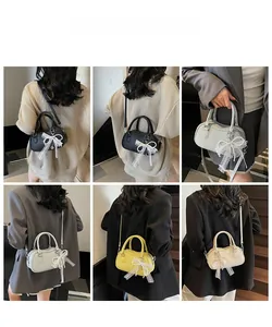 Detail view of stylish Boston bags in multiple colors with lace bows and pearl charms