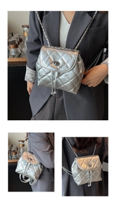 Detailed macro view of silver metallic quilted texture and silver chain strap on backpack