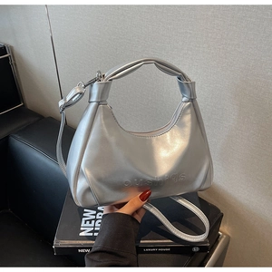 Detailed macro of silver metallic hobo bag with knotted handle and embossed logo
