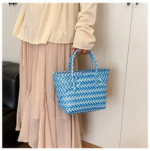 Close-up of blue and white woven tote bag showing chevron texture and stylish carry style