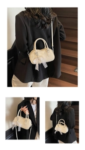 Detail of cream white leather Boston bag with litchi texture and pearl lace pendant