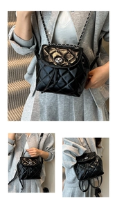 Close-up of black quilted mini backpack with silver metal turn-lock and chain straps