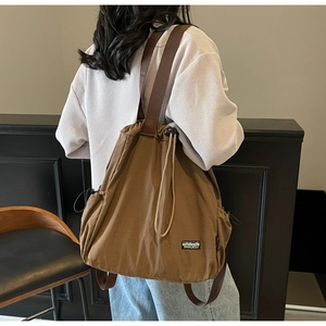 Sac à dos marron à cordon en nylon porté avec bretelles réglables et logo de montagne