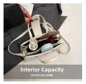 Vue de dessus du sac bandoulière blanc crème montrant l'intérieur spacieux et cosmétiques