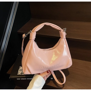 Pink waxed leather handbag with embossed letters on a wooden step for a classy look