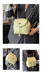Detailed view of light yellow quilted mini backpack with woven chain strap and turn-lock