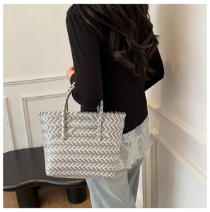 Detail of hand-woven geometric pattern and sturdy handles on a grey and white tote bag