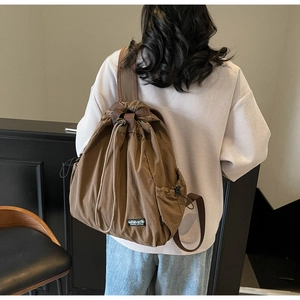 Détail du sac à dos en toile marron avec cordon de serrage et larges bretelles réglables