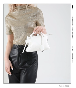 Nahaufnahme einer weißen Mini-Handtasche aus Kunstleder mit modischem Outfit